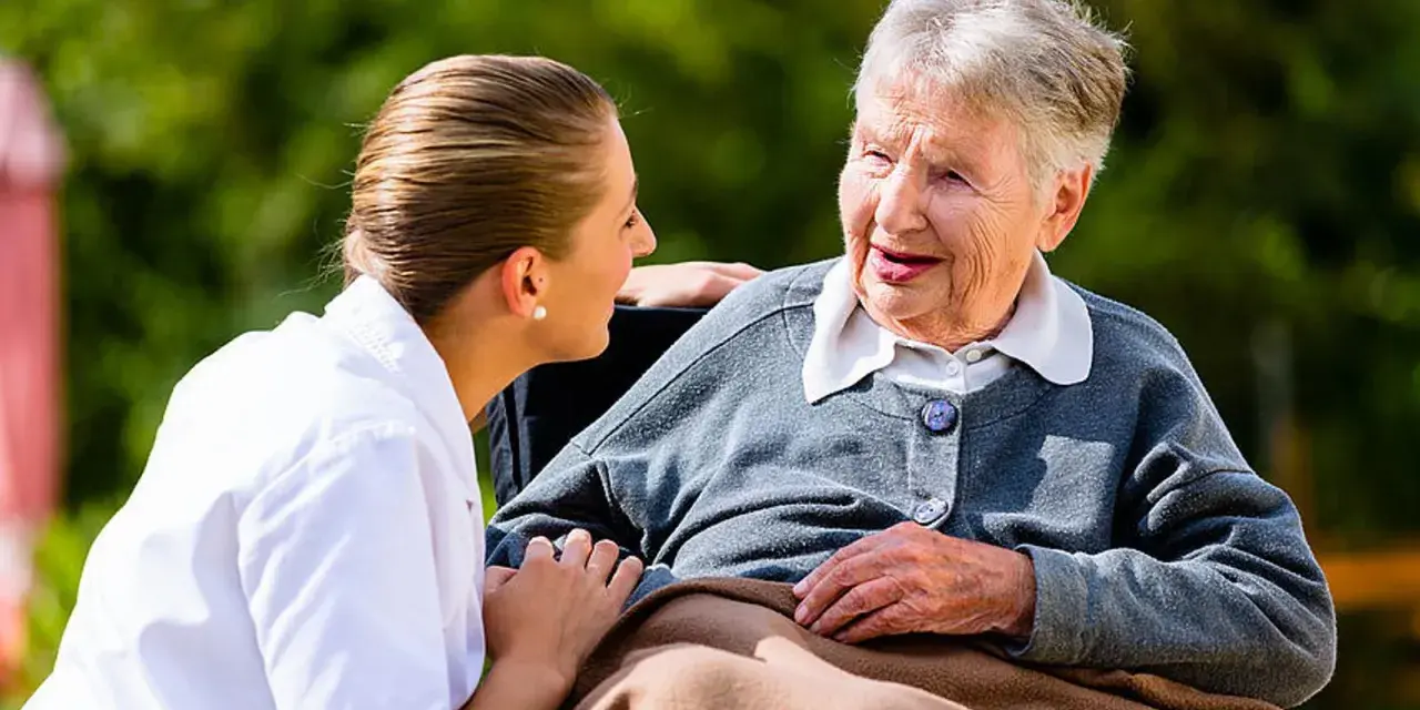 Pflegekraft spricht einfühlsam mit älterer Dame, Validation Demenz im Fokus.