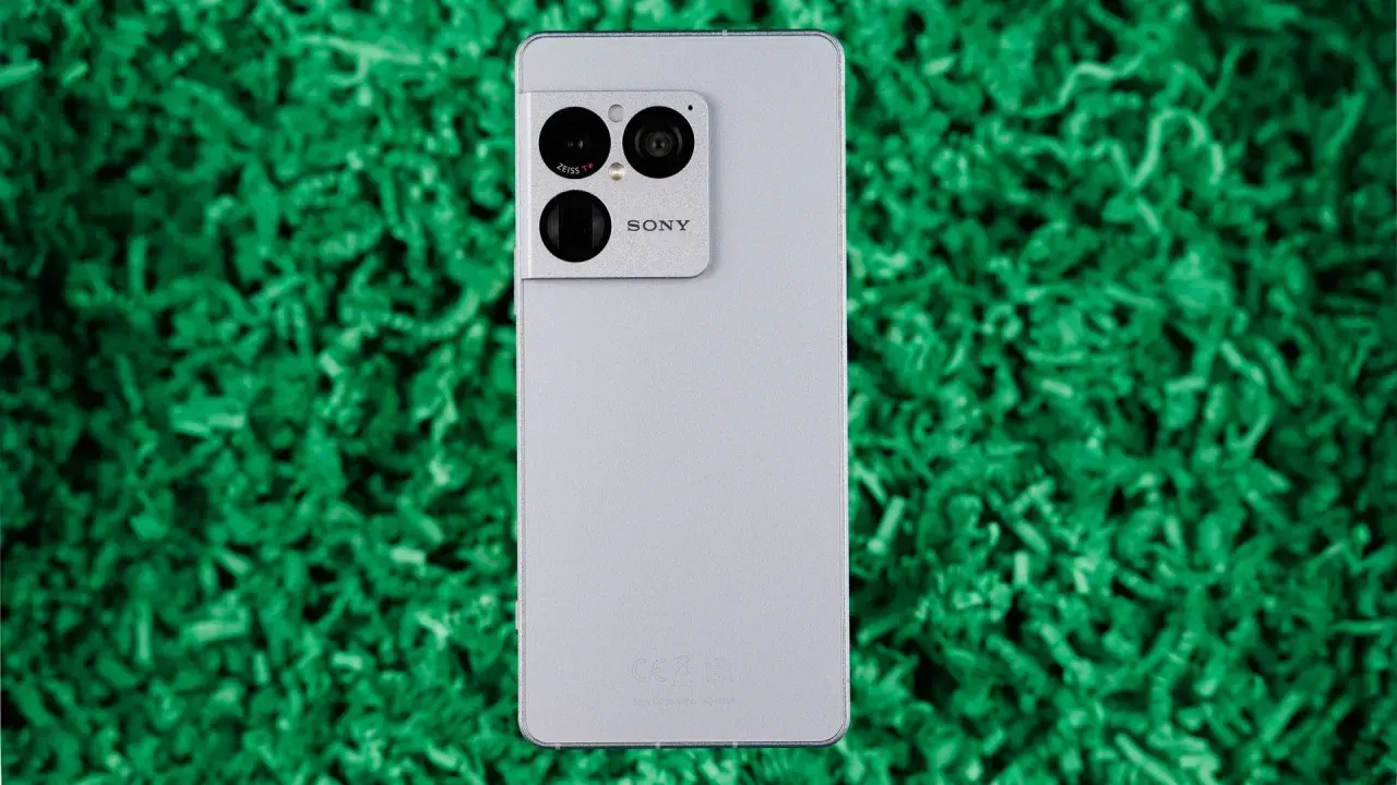 Srebrny smartfon Sony Xperia 1 VIII z potrójnym aparatem Zeiss na zielonym tle.