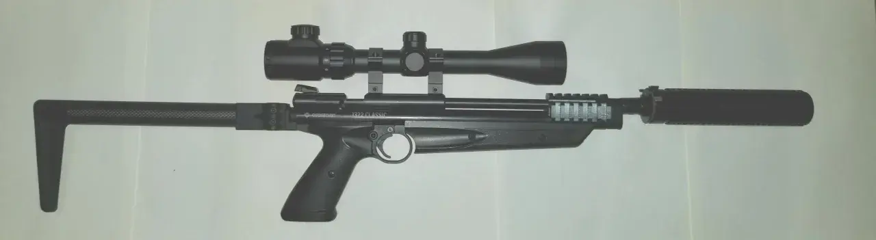 Crosman 1322 z lunetą i tłumikiem, gotowy do akcji.