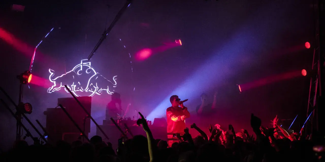 Raper na scenie w otoczeniu tłumu i neonowego logo Red Bulla. Już wkrótce kolejne emocjonujące koncerty Warszawa 2026!
