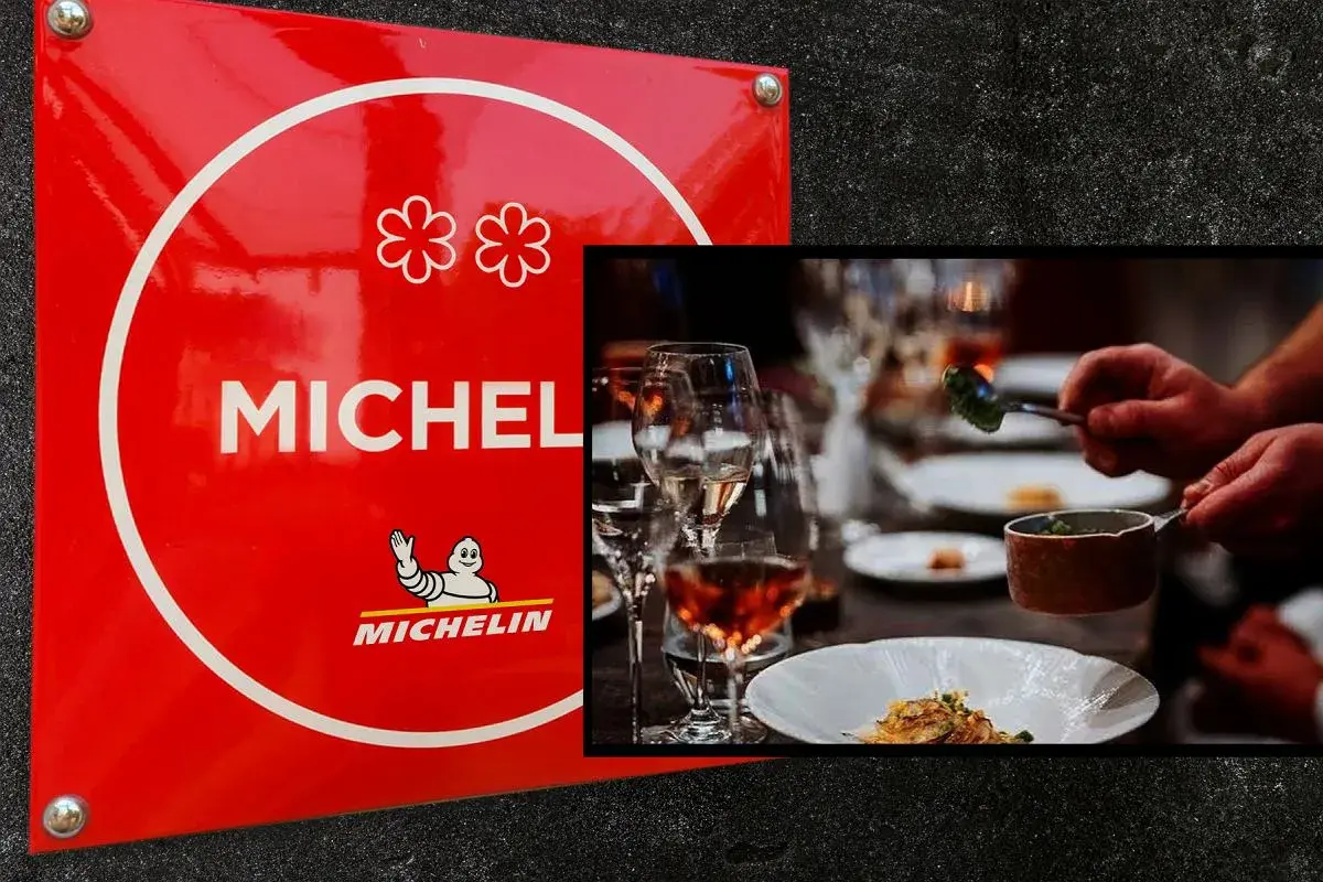 Czerwona tablica z dwoma kwiatkami symbolizującymi gwiazdkę Michelin. Obok elegancko nakryty stół, gdzie kucharz serwuje danie.