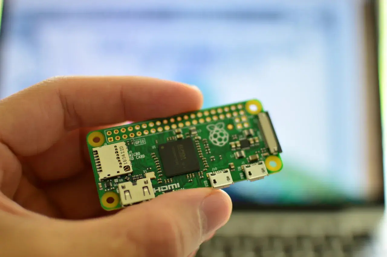 Dłoń trzyma miniaturową płytkę Raspberry Pi Zero W, gotową do projektów. To wszechstronne raspberry pi zastosowanie w elektronice.