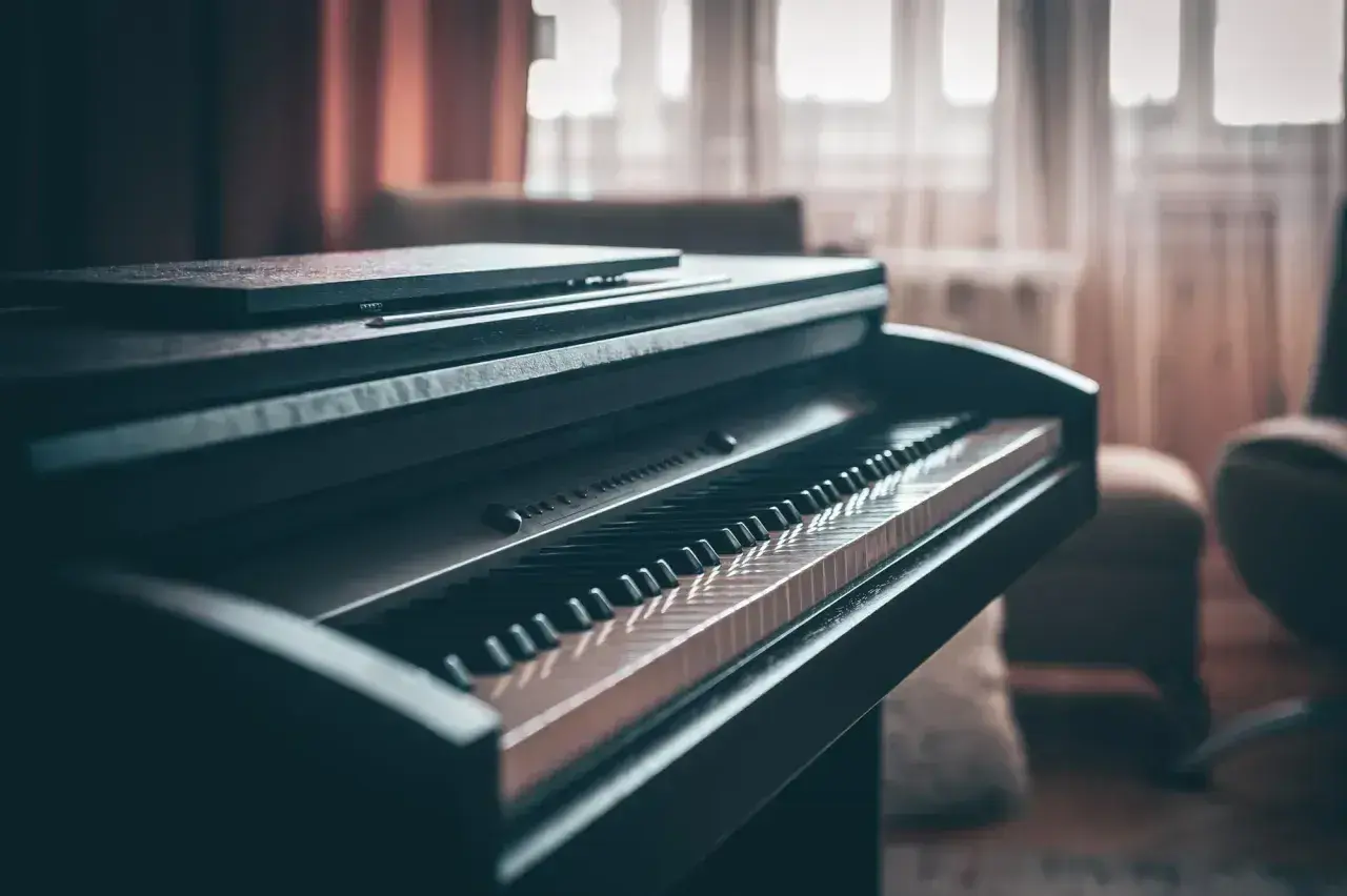 Ciemne pianino cyfrowe z klawiaturą w zbliżeniu. Zastanawiasz się, ile waży pianino? Ten instrument jest solidny.