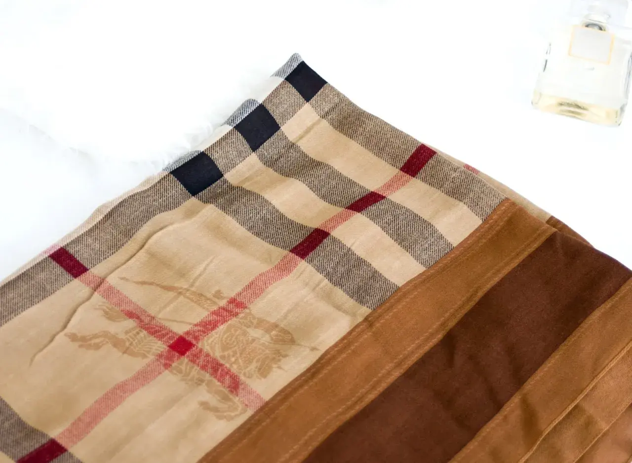 Jak rozpoznać oryginalny szalik Burberry? Zwróć uwagę na charakterystyczną kratę, subtelny wzór jeźdźca i jakość materiału.