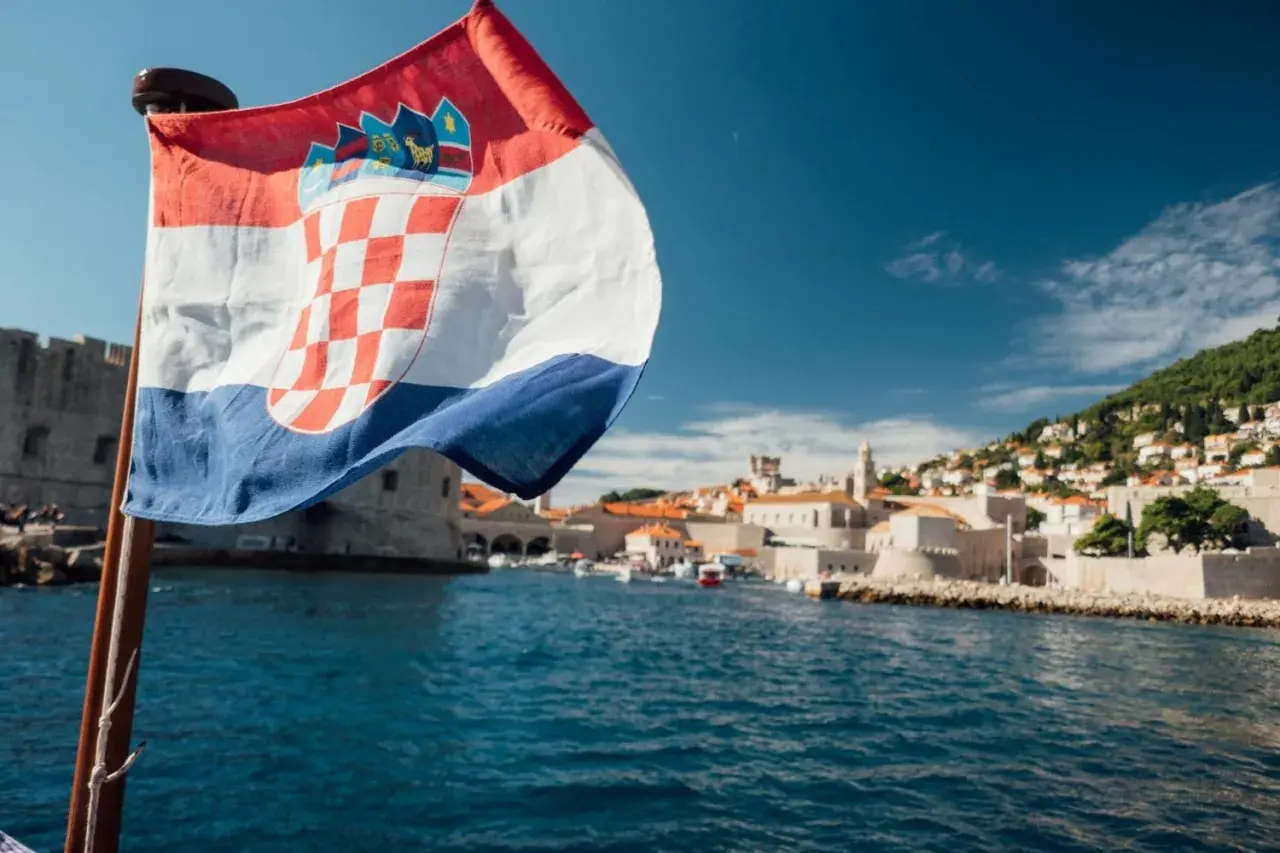 Chorwacka flaga na tle Dubrownika. Planujesz podróż? Sprawdź, co zabrać do Chorwacji jadąc samochodem.