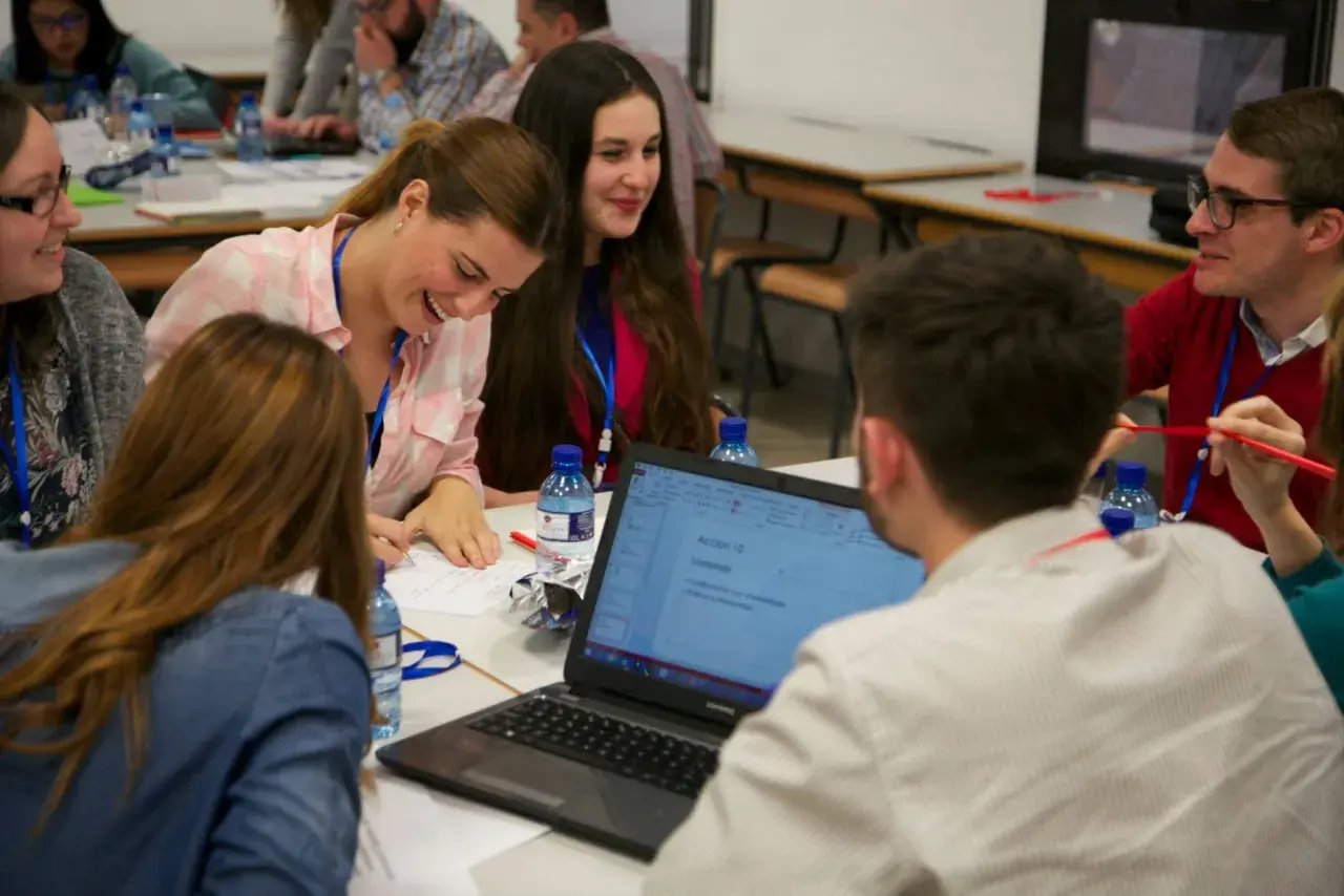 Jóvenes participan en actividades para trabajar la asertividad en el aula, colaborando en un proyecto.