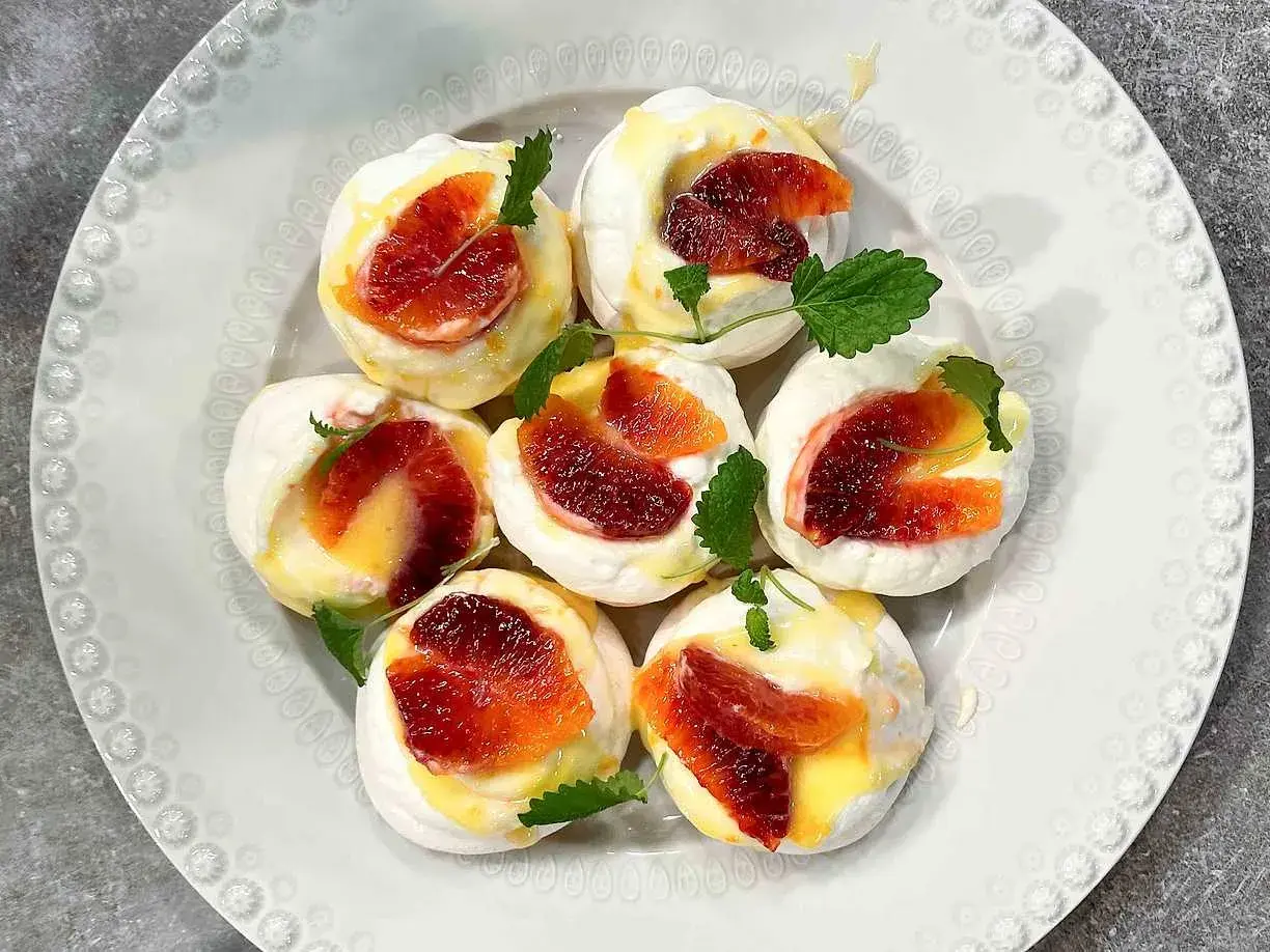 Små marängbottnar med krämig vaniljsås och blodapelsin. Ett enkelt dessert recept som passar perfekt till fikat.