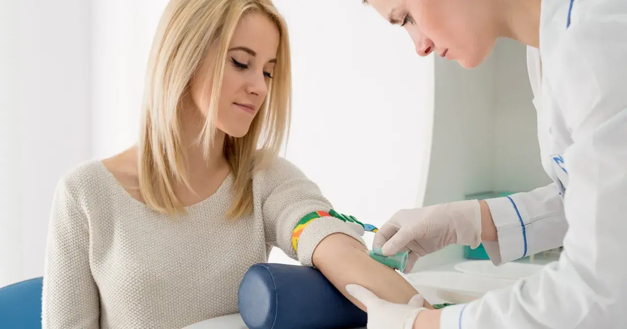 Pielęgniarka pobiera krew od pacjentki. Wyniki badań wskazują na rdw-sd podwyższone, co może wymagać dalszej diagnostyki.