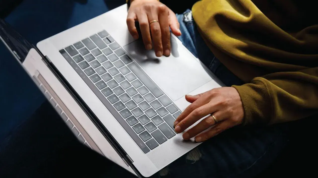 Person arbetar på laptop, kanske bokför bokföring för avdrag enskild firma.
