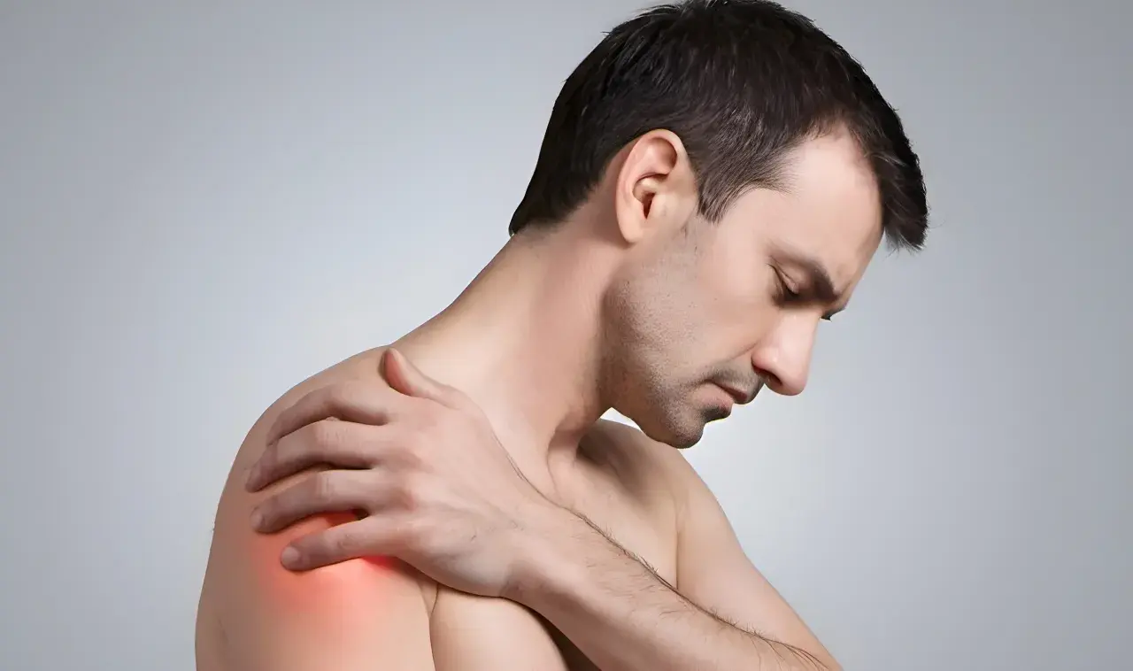 Mann mit schmerzender Schulter, die auf eine Frozen Shoulder hindeutet. Osteopathie kann hier Linderung verschaffen.
