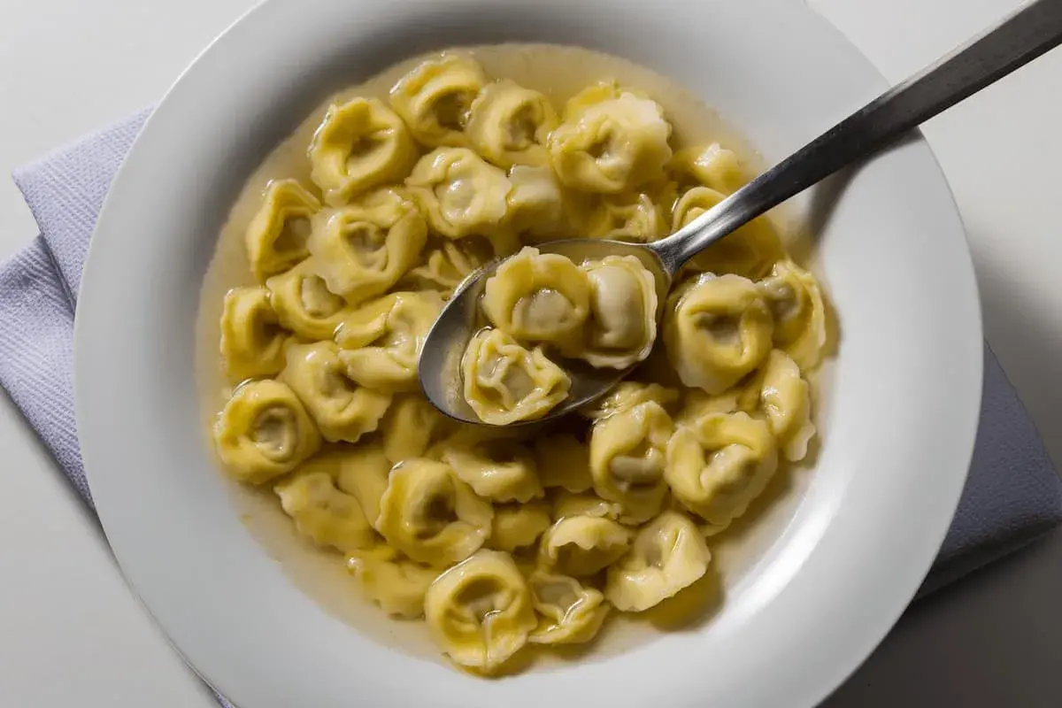 Tortellini in brodo, un classico da provare se ti chiedi cosa mangiare a Ravenna. Un piatto caldo e confortante.