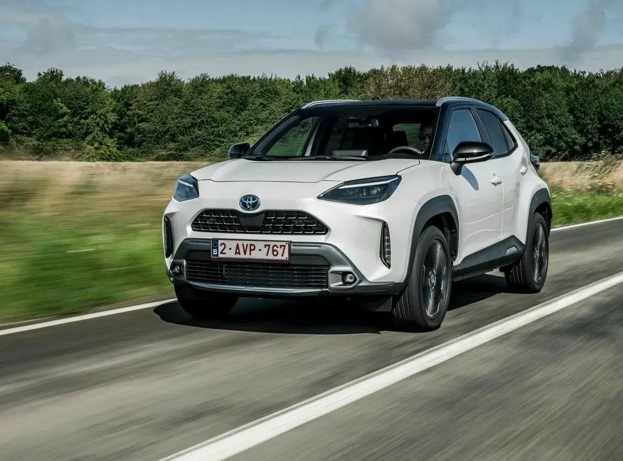 Biały Toyota Yaris Cross na drodze, idealny do miasta i na wakacje. Sprawdź nasze toyota yaris cross opinie!