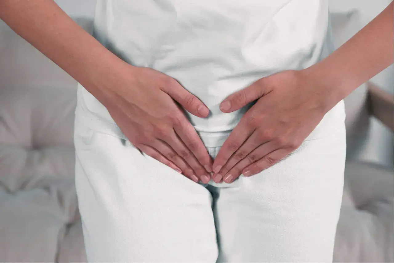 Mani che coprono l'area pelvica, suggerendo preoccupazione per ureaplasma parvum in gravidanza.