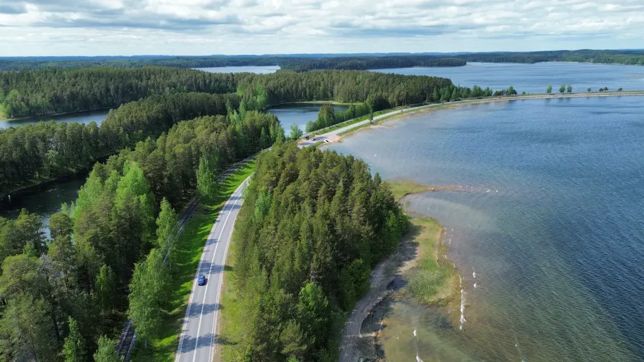 Malownicze jeziora i lasy Finlandii. Droga wije się wśród zieleni, idealna na podróż, by odkryć, co zobaczyć w Finlandii.