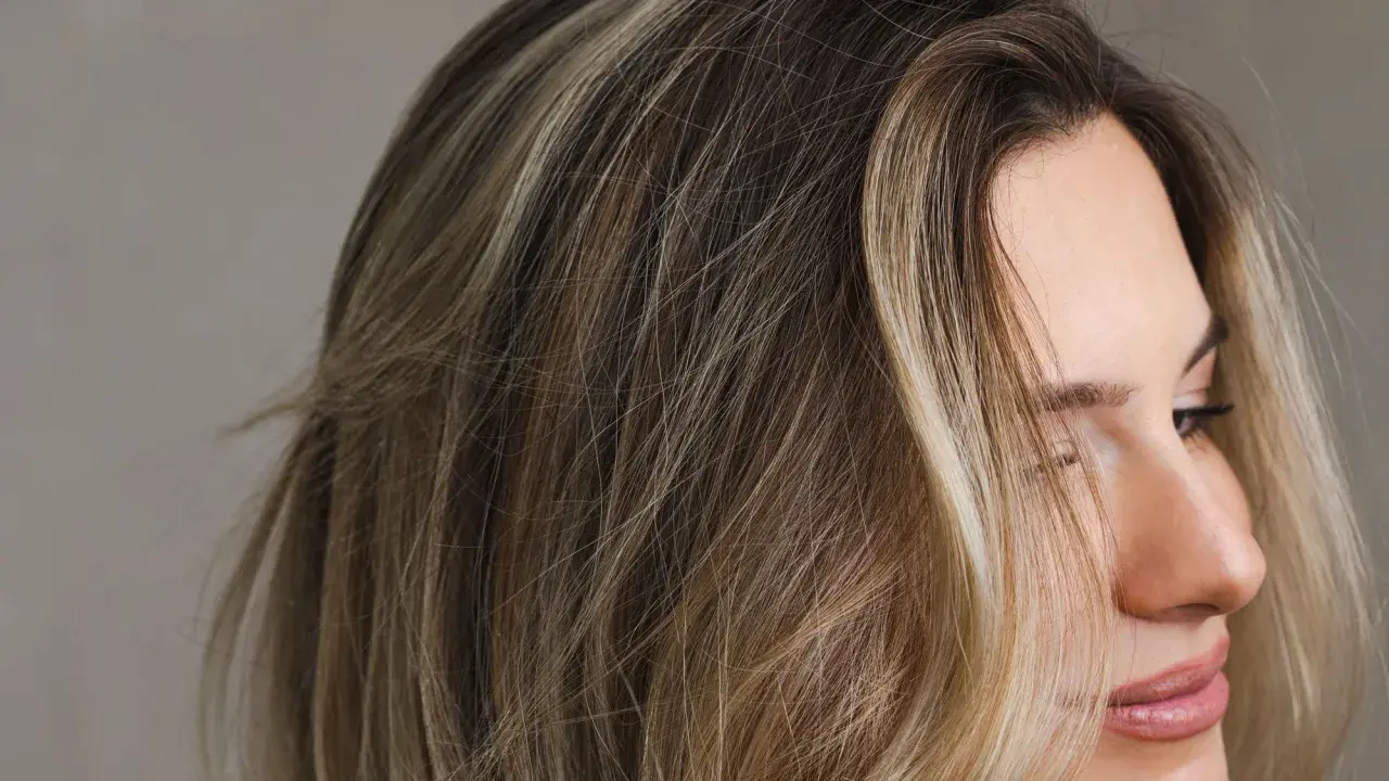 Mechas melting en cabello rubio y castaño, creando un efecto degradado natural.