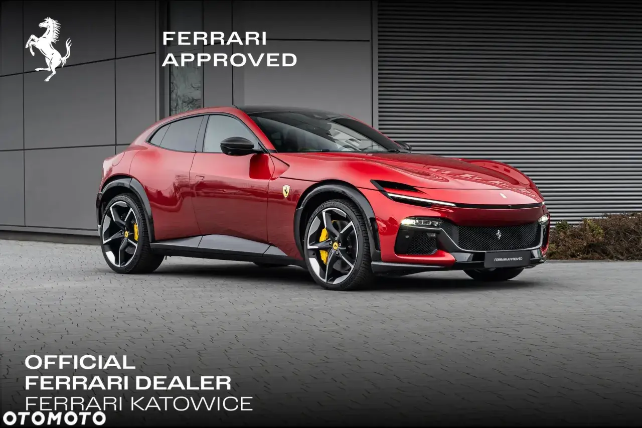 Czerwony Ferrari Purosangue, luksusowy SUV, prezentuje się dumnie przed budynkiem dealera.