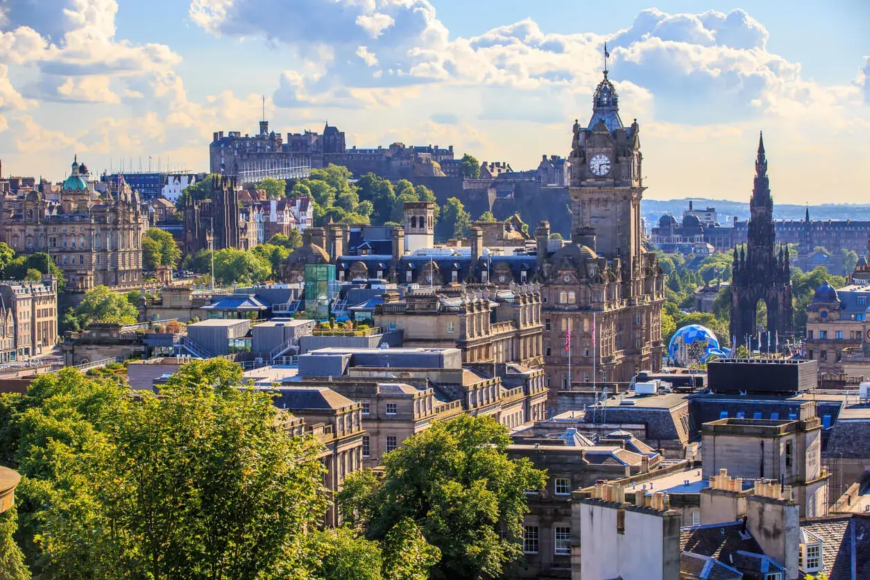 Edinburghs Skyline mit Schloss und Uhrenturm. Die beste Reisezeit für diese Aussicht ist im Sommer, wenn die Bäume grün sind.