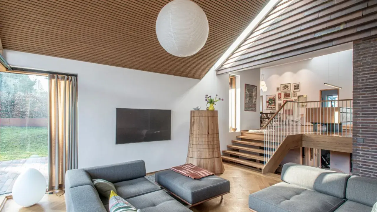 Gemütliches Wohnzimmer in einem Split-Level-Haus mit Holzakzenten, Treppen und gemütlichen Sofas.