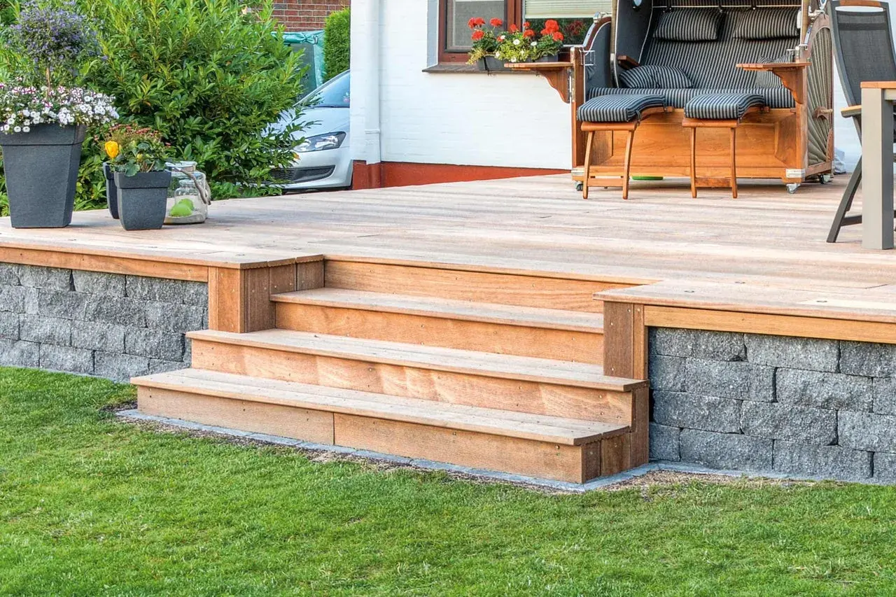 Eine schöne Holztreppe mit 2 Stufen, die man leicht selber bauen kann, führt zur Terrasse.