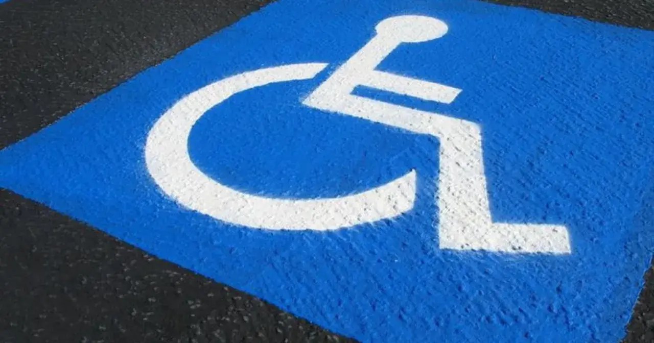 Niebieskie pole z białym symbolem wózka inwalidzkiego. Czy parking dla niepełnosprawnych jest płatny?