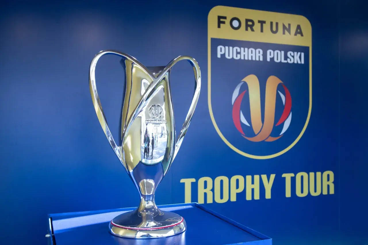 Błyszczący puchar Fortuna Pucharu Polski na tle niebieskiej ściany z logo i napisem "Trophy Tour".