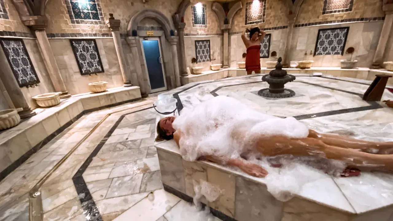 Kobieta w pianie w łaźni. Hammam co to? To tradycyjna turecka łaźnia parowa, miejsce relaksu i oczyszczenia.