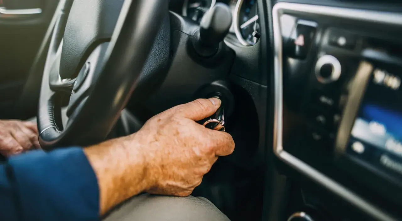 Mano insertando llave en el encendido. Al poner en marcha un motor de gasolina es conveniente tener el coche listo.
