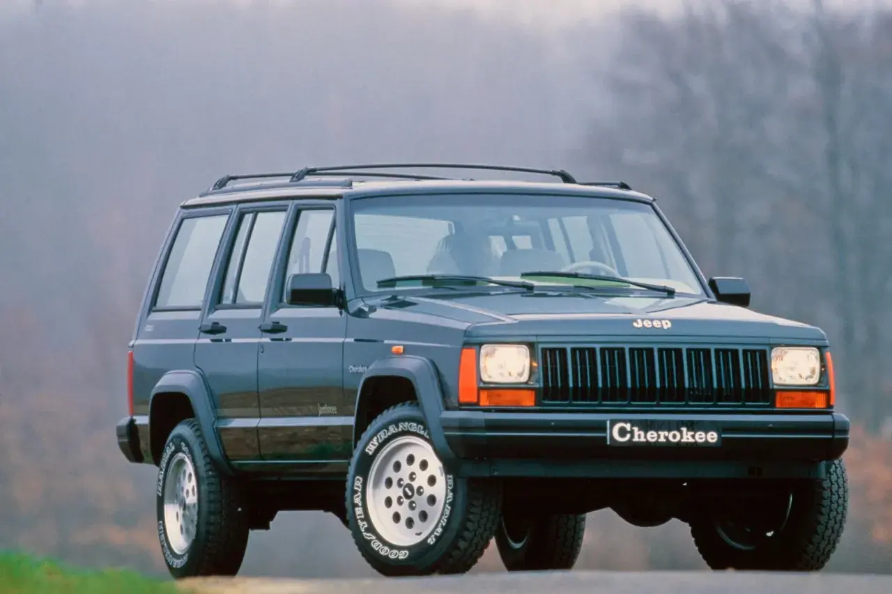 Klasyczny Jeep Cherokee ZJ z lat 90. na tle mglistego krajobrazu.
