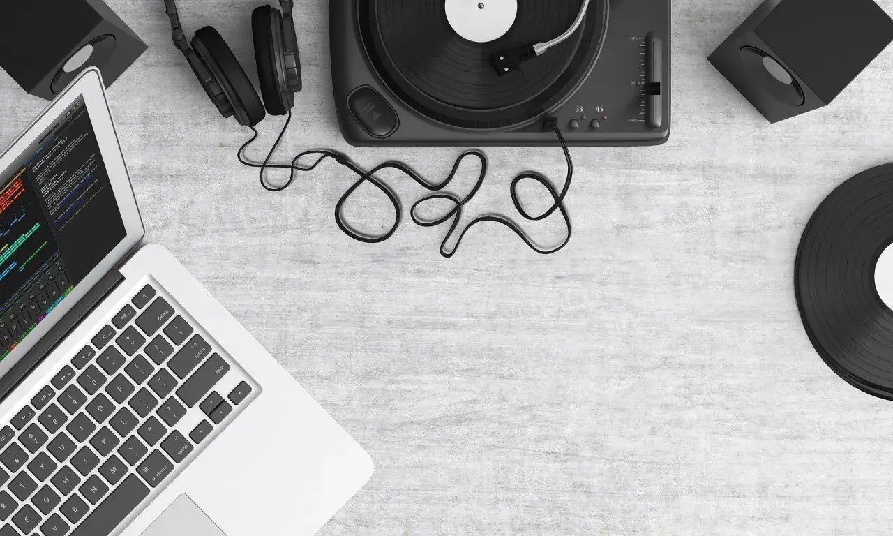 Laptop z programem do edycji dźwięku, gramofon, słuchawki i płyty winylowe. Tworzenie muzyki, sample co to?