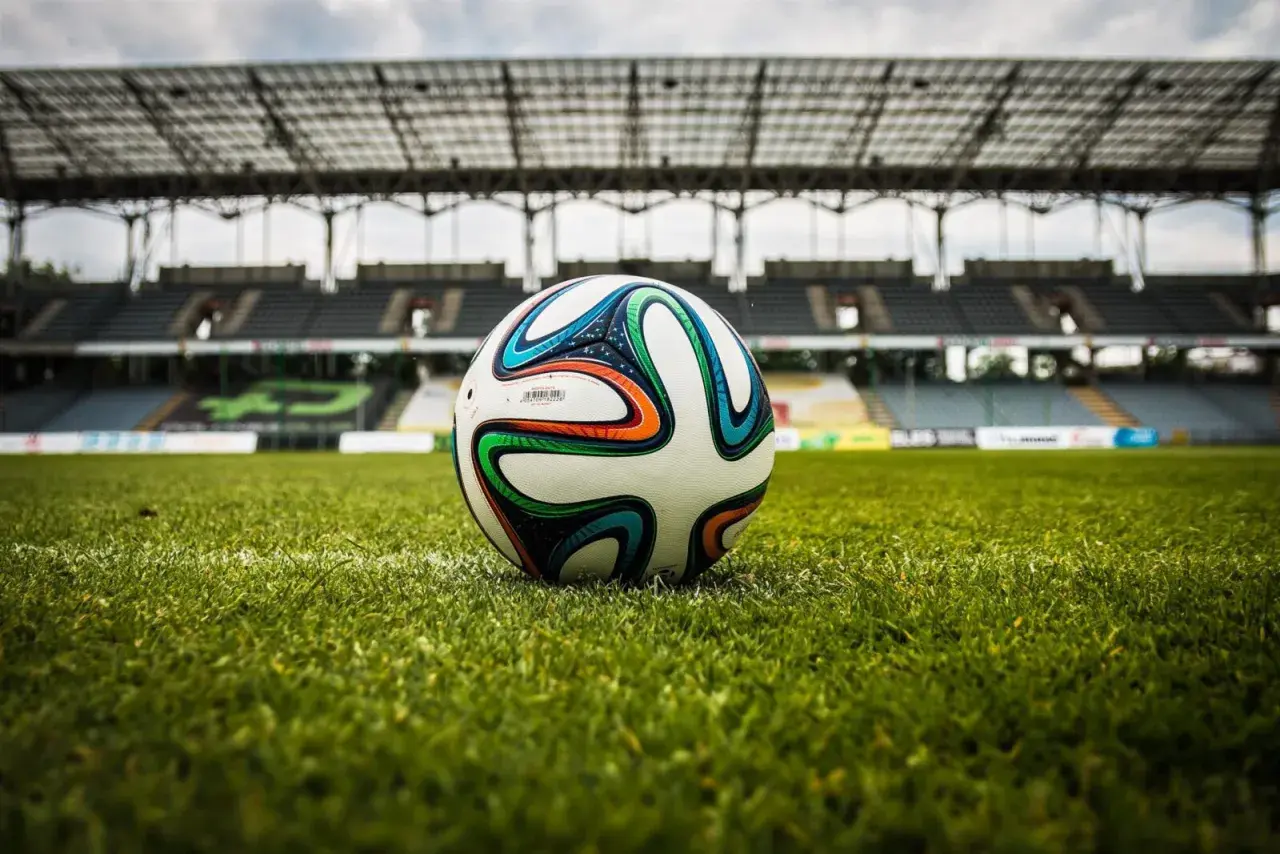 Piłka na murawie stadionu, gotowa do gry. Czekamy na sygnał, by dowiedzieć się, ile trwa dogrywka w piłce nożnej.