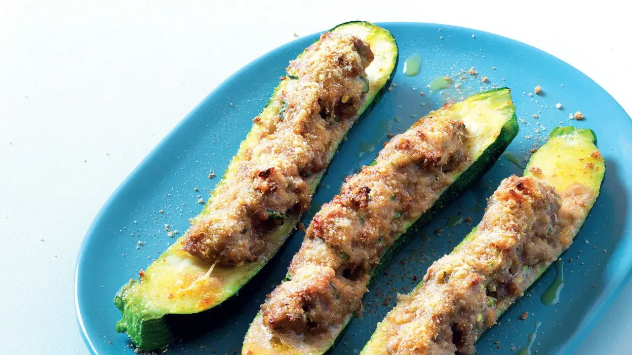 Zucchine ripiene velocissime, dorate e croccanti, servite su un piatto blu. Un piatto semplice e gustoso.