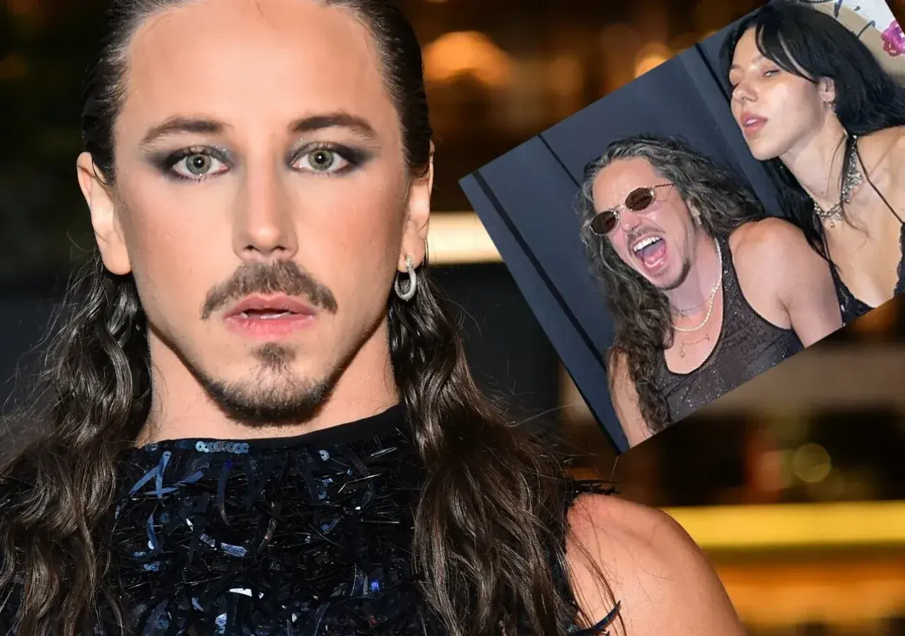 Michał Szpak z żoną, uśmiechnięty i w okularach, na zdjęciu w tle.
