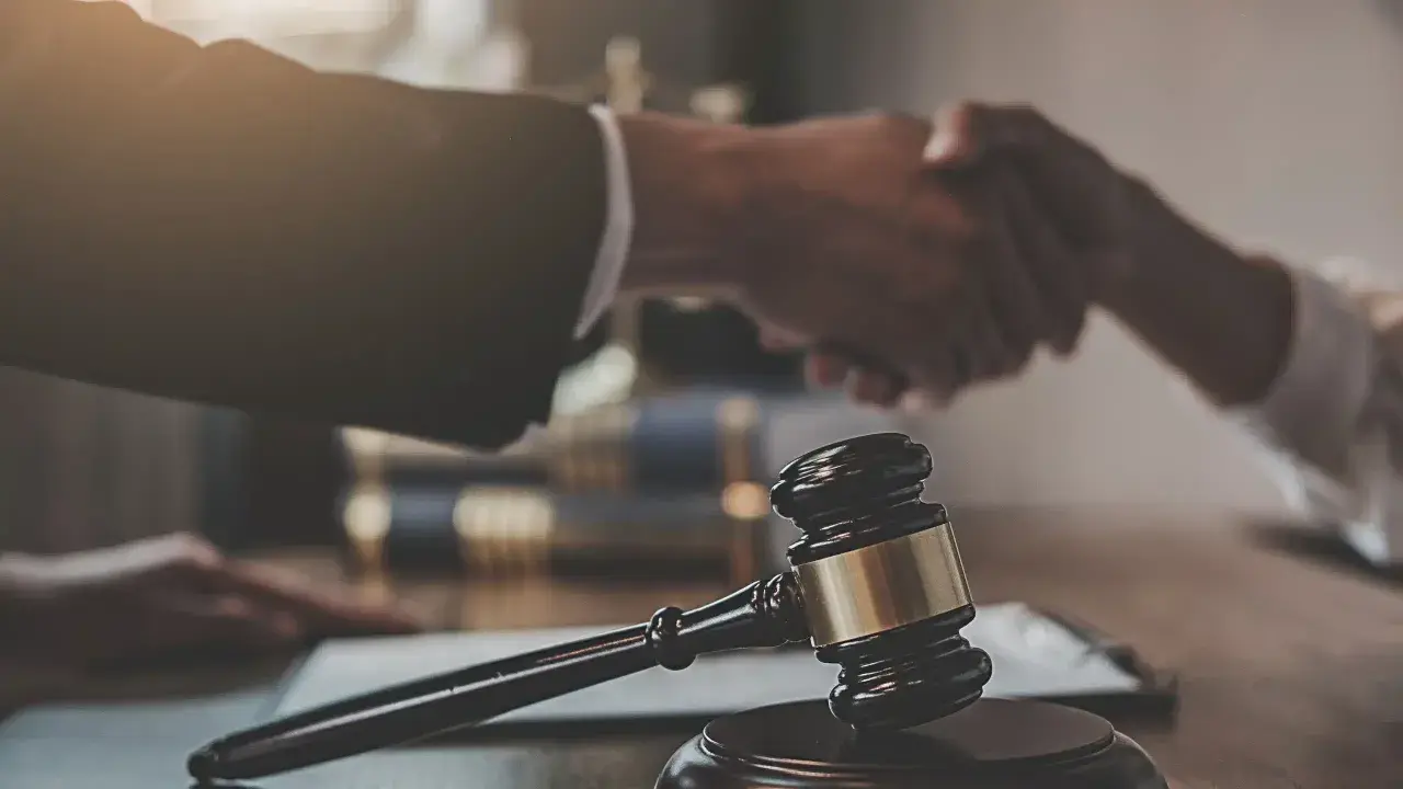 Sądowy młotek i uścisk dłoni symbolizują zakończenie sprawy. Libor co to? To może być początek nowego rozdziału.
