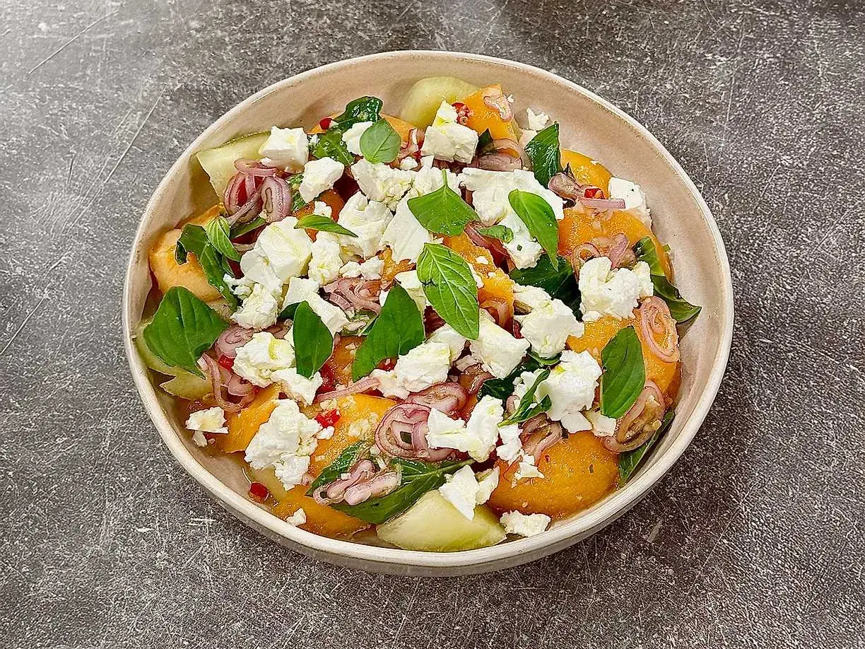En uppfriskande melonsallad med fetaost, rödlök och basilika. Perfekt sommarbuffé eller lätt lunch.