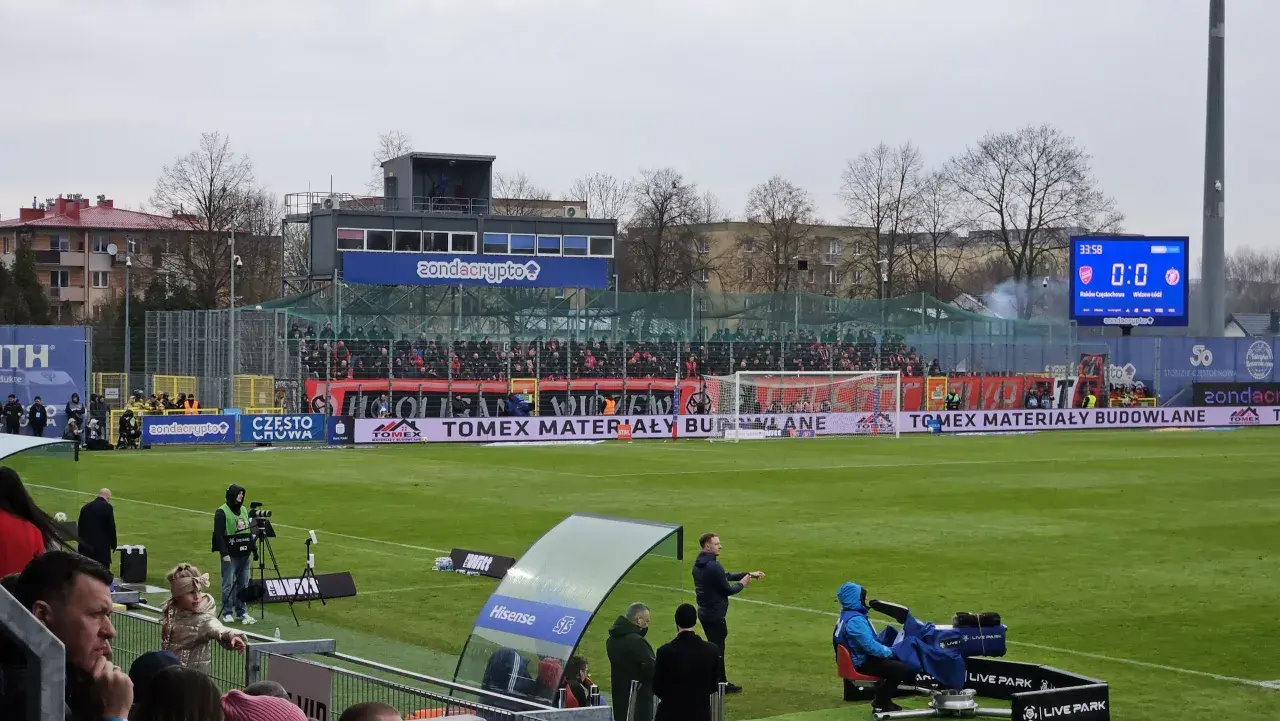 Mecz Raków Częstochowa – Widzew Łódź, wynik 0:0. Na boisku widać zawodników, kamery i trybuny pełne kibiców.
