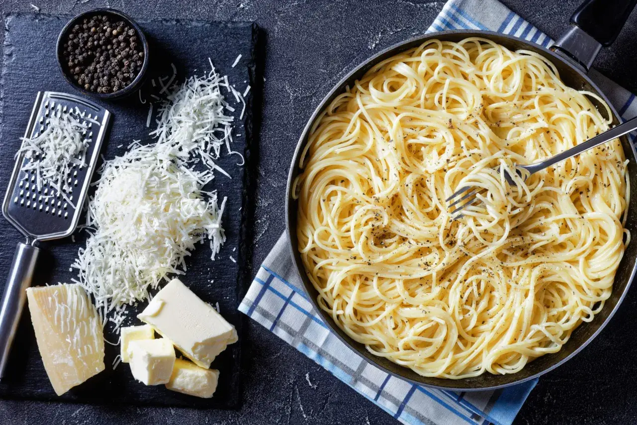 Spaghetti conditi con burro e pepe, pronti per essere arricchiti con pecorino, fonte di proteine.