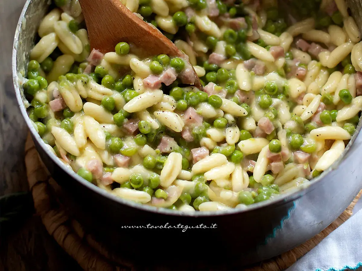 Pasta con prosciutto cotto e piselli, un piatto cremoso e saporito, pronto per essere gustato.