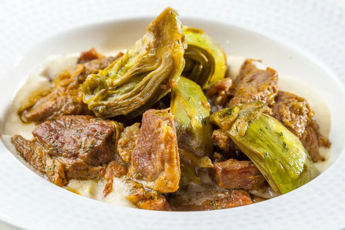 Un saporito agnello con carciofi in umido, un piatto tradizionale che profuma di casa.