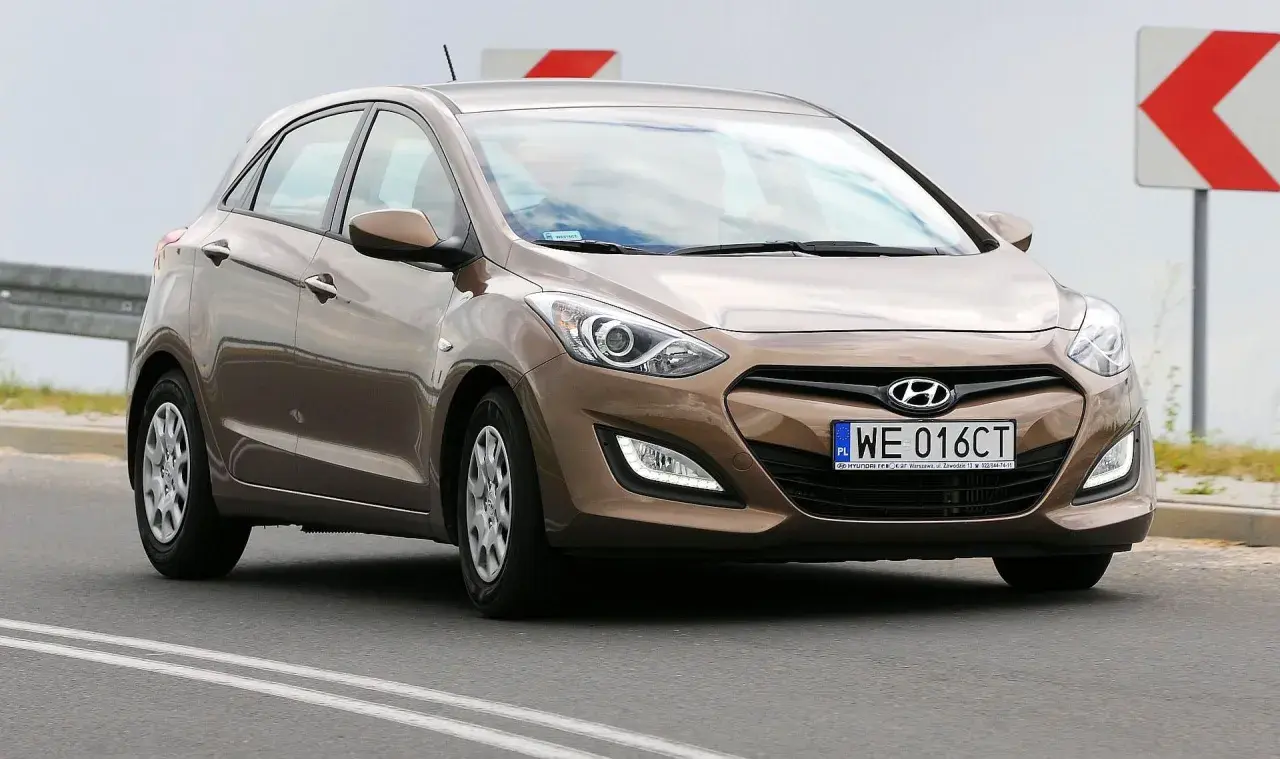Brązowy Hyundai i30 2015 na drodze, z tablicą rejestracyjną WE 016CT.