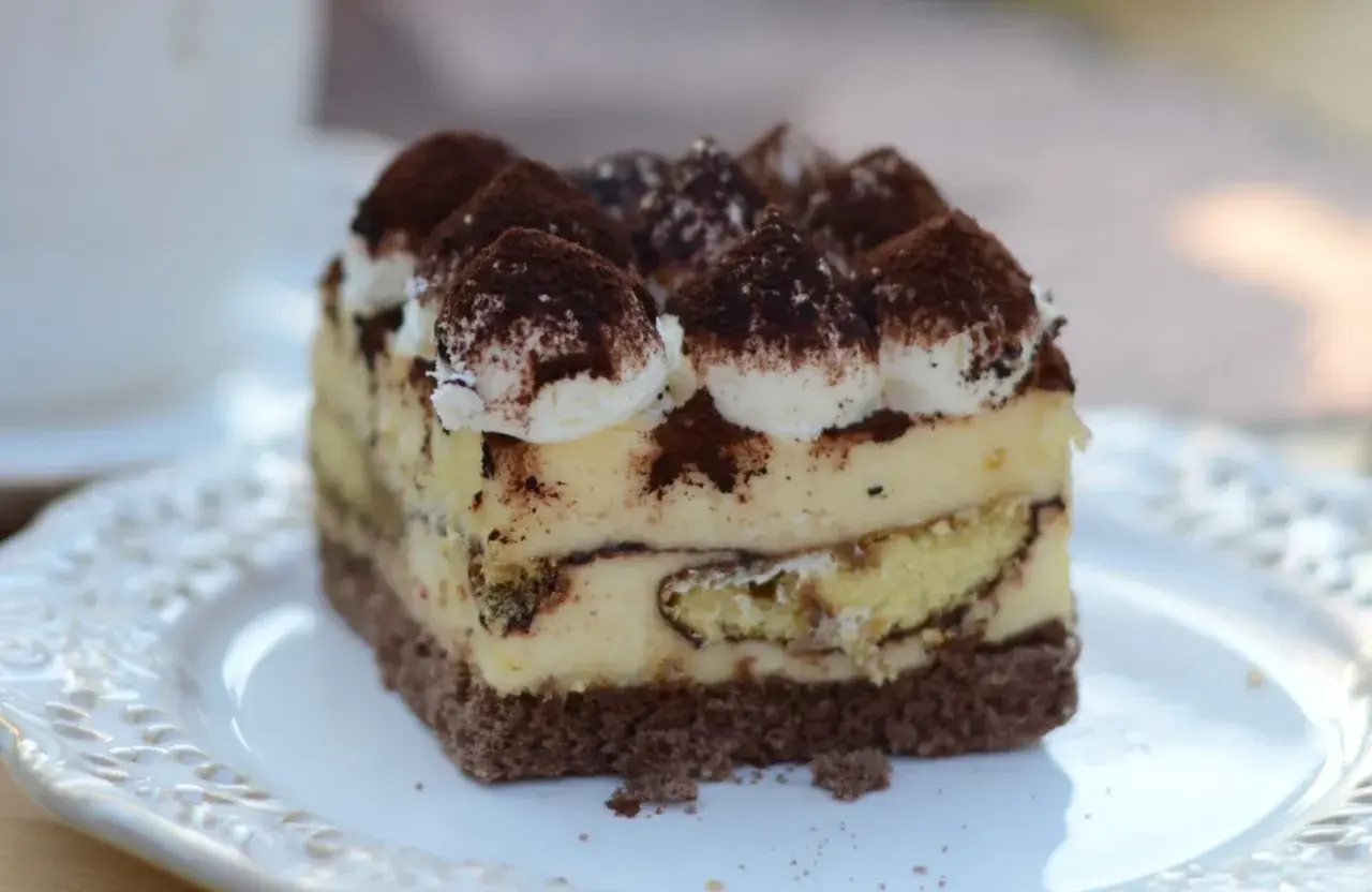 Pyszne tiramisu Ani gotuje, warstwy biszkoptu i kremu, posypane kakao.