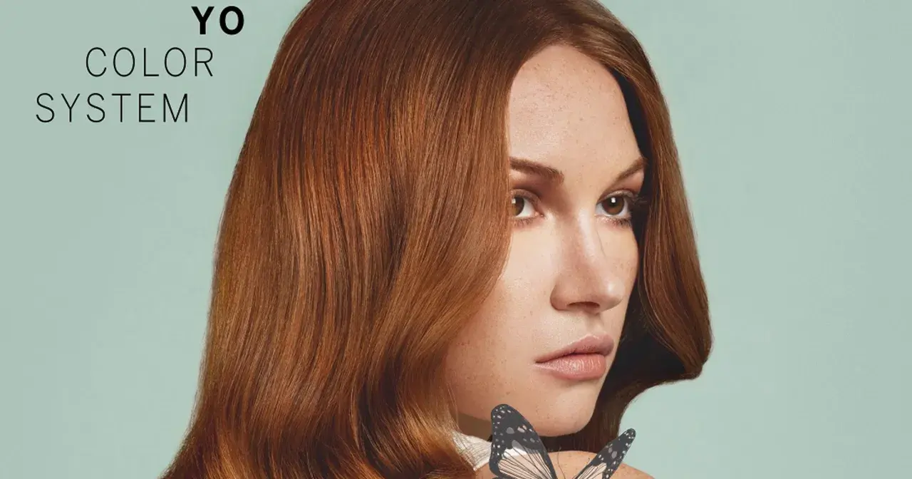 Kobieta z rudymi włosami i motylem na ramieniu, tekst "YO COLOR SYSTEM".