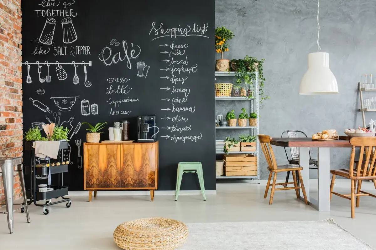 Kreative Ideen für einen kleinen Partyraum: Tafelwand mit Einkaufsliste und Café-Menü, Vintage-Schrank, Pflanzen und Essbereich.