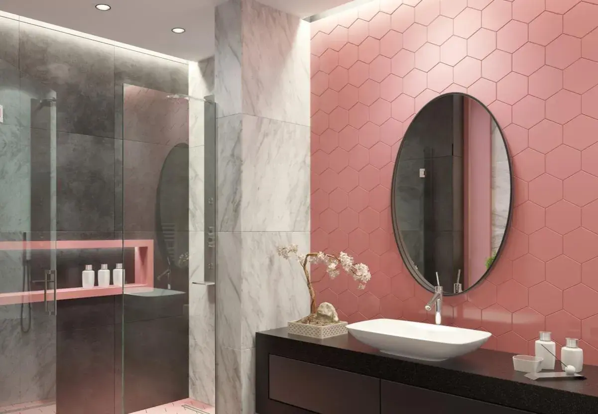 Bagno moderno con doccia, dove le piastrelle rosa a nido d'ape contrastano con il grigio e il marmo.