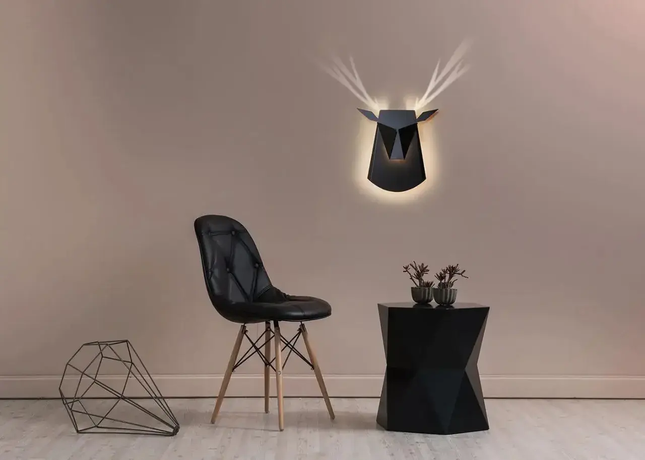 Lámpara pared negra con diseño de ciervo geométrico, ilumina la estancia con un toque moderno.