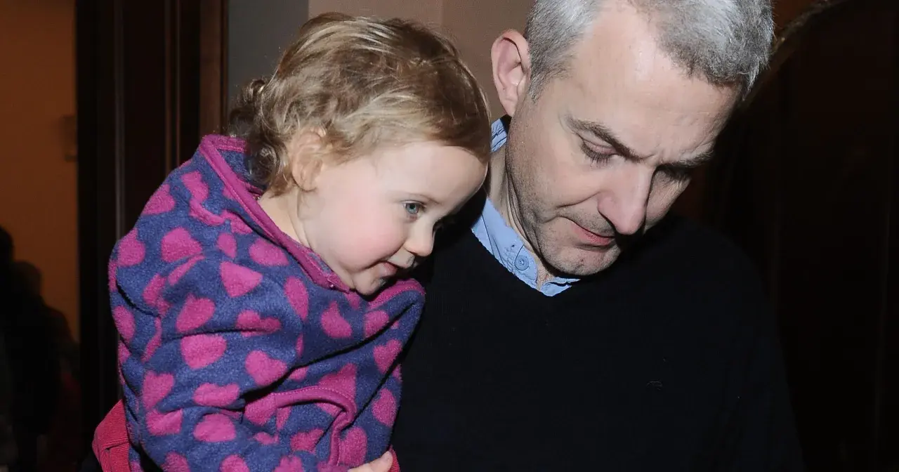 Hubert Urbański z córką, która przytula się do niego w bluzie w serduszka.