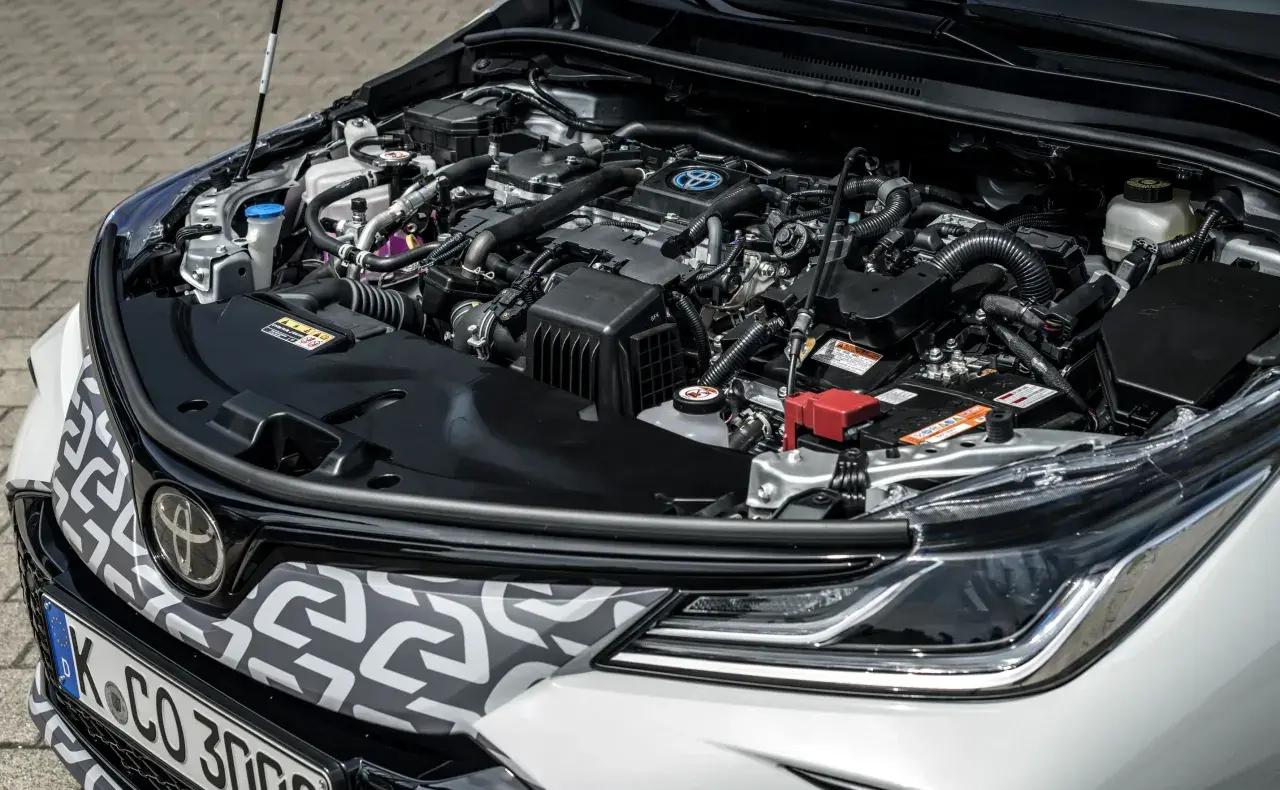 Silnik hybrydowy Toyoty Matrix, pełen przewodów i elementów, gotowy do pracy.