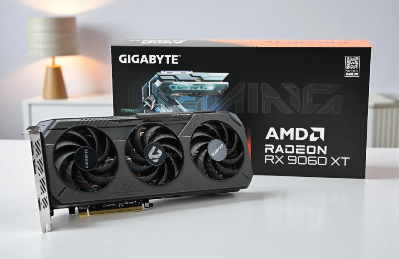 Gigabyte Gaming Grafikkarte mit AMD Radeon RX 9060 XT. Die Karte hat drei Lüfter und die Verpackung ist im Hintergrund zu sehen.