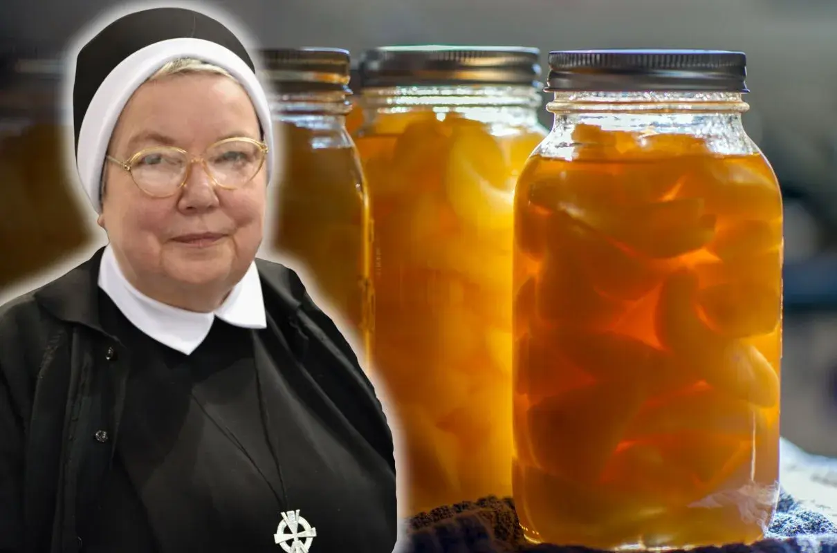 Siostra w okularach prezentuje słoiki z przetworzonymi gruszkami w occie.