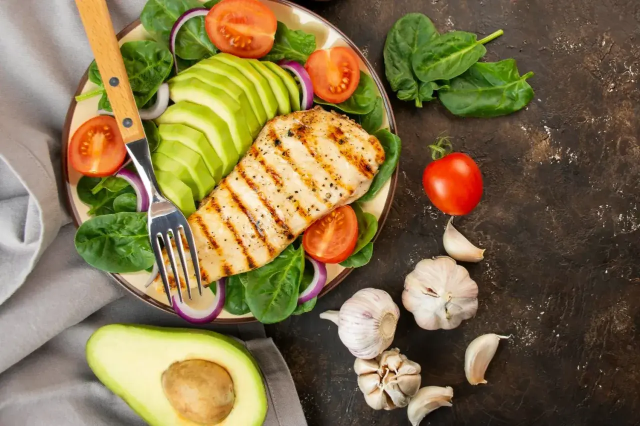 Pechuga de pollo a la parrilla con aguacate, espinacas y tomate. Ideal para una dieta antiinflamatoria menopausia.