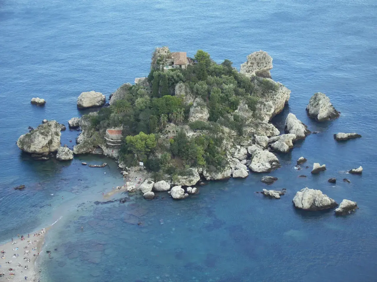 Isola Bella, una perla tra le spiagge della Sicilia orientale, con scogli e vegetazione lussureggiante.